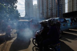 Exhaust fumes are seen coming from a vehicle stopped at traffic lights in Jakarta