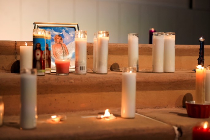 A photo of cinematographer Halyna Hutchins, who died after being shot by Alec Baldwin on the set of his movie "Rust", rests among candles at a vigil in Albuquerque, New Mexico, U.S.