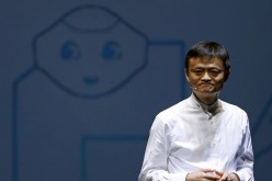 Jack Ma, founder and executive chairman of China's Alibaba Group, speaks in front of a picture of SoftBank's human-like robot named 'pepper' during a news conference in Chiba, Japan