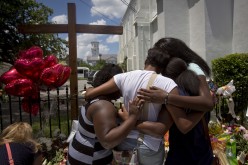 Family members of a victim hug as they pay their respects in front of the Emanuel African Methodist Episcopal Church, where a mass shooting took place, in Charleston, South Carolina, 