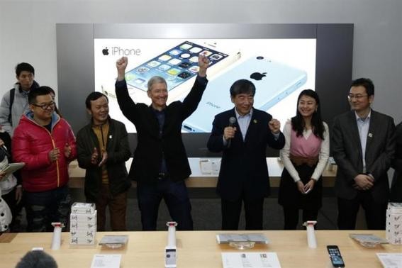 Apple Inc.'s CEO Tim Cook next to tech representatives from China at Apple store.