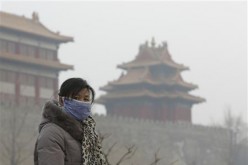 A Chinese woman wears a mask outside the Forbidden City due to heavy haze.