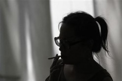 A Chinese woman smokes a cigarette.