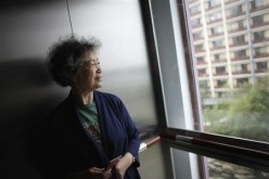Zhu Yuefeng, 75, stands in the elevator of her apartment building. 
