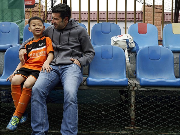 Luis Figo talks to a young Chinese boy who attended a football clinic conducted by the Figo Football Academy.