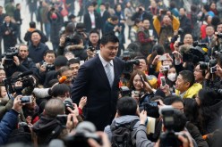 Yao Ming walks past the media on his way to the Great Hall of the People in Beijing.