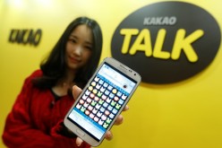 A Kakao Talk employee displays a mobile game on a smartphone at the company’s headquarters in Seongam, South Korea.