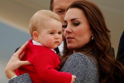 Britain's Catherine, the Duchess of Cambridge, holds her son Prince George as they prepare to board a plane with her husband Prince William (not pictured) to depart Canberra April 25, 2014. 