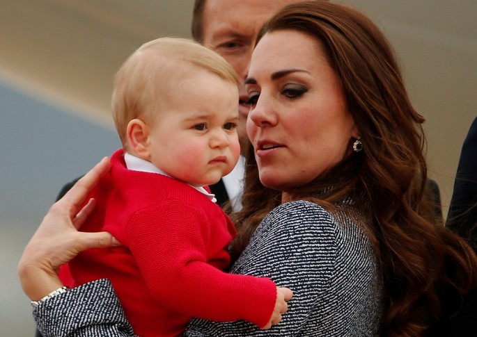 Britain's Catherine, the Duchess of Cambridge, holds her son Prince George as they prepare to board a plane with her husband Prince William (not pictured) to depart Canberra April 25, 2014. 