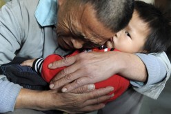 Wang Bangyin, a local farmer, holds his rescued son after the pair were reunited at Guiyang Welfare Centre for Children in Guiyang, Guizhou Province, Oct. 29, 2009. 