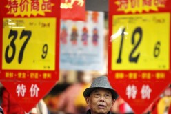 A customer looks at price tags at a supermarket in Huaibei, Anhui Province, Feb. 10, 2015. 