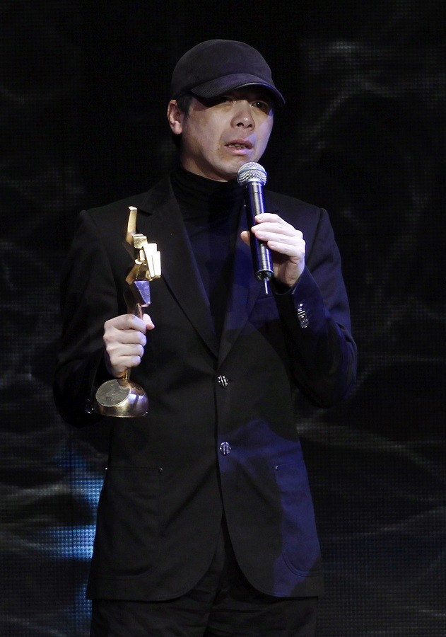 Chinese director Feng Xiaogang receives the Best Top Grossing Film award for the movie "Aftershock" during the Asian Film Awards ceremony in Hong Kong, March 21, 2011.