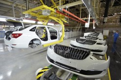 An employee looks on next to an assembly production line of Buick cars at a General Motors factory in Wuhan, Hubei Province, Jan. 28, 2015.