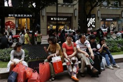 Shoppers rest outside a shopping mall on Russell Street at Hong Kong's Causeway Bay shopping district, June 17, 2014. 