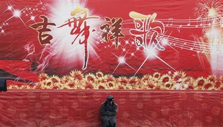 A guard sits in front of a Chinese New Year celebration stage in China.