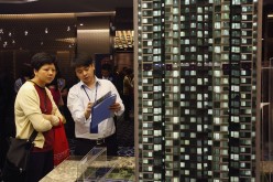A potential buyer listens to a property sales agent at a promotional event in Hong Kong, Sept. 5, 2013. 