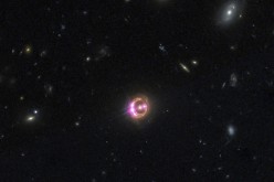 Multiple images of a distant quasar are visible in this undated combined view from NASA’s Chandra X-ray Observatory and the Hubble Space Telescope.