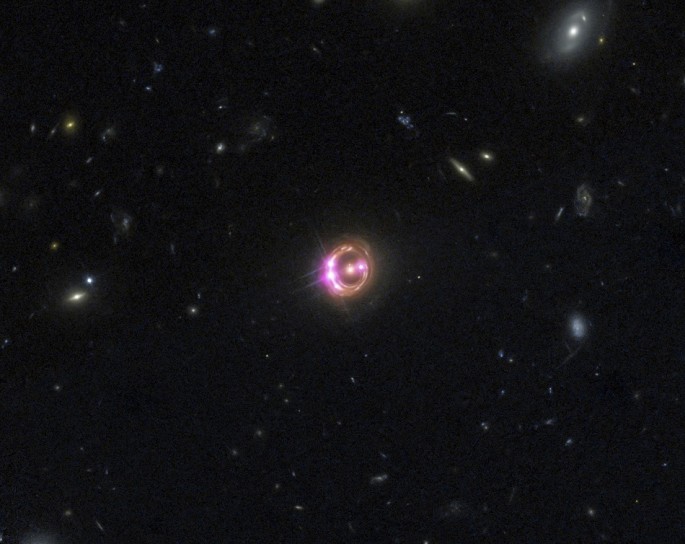 Multiple images of a distant quasar are visible in this undated combined view from NASA’s Chandra X-ray Observatory and the Hubble Space Telescope.