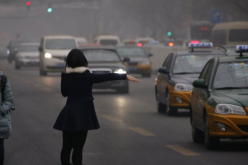 A woman trying to hail a taxi in China. 