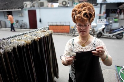 A female businesswoman and shop owner prepares items in her store in Shanghai.