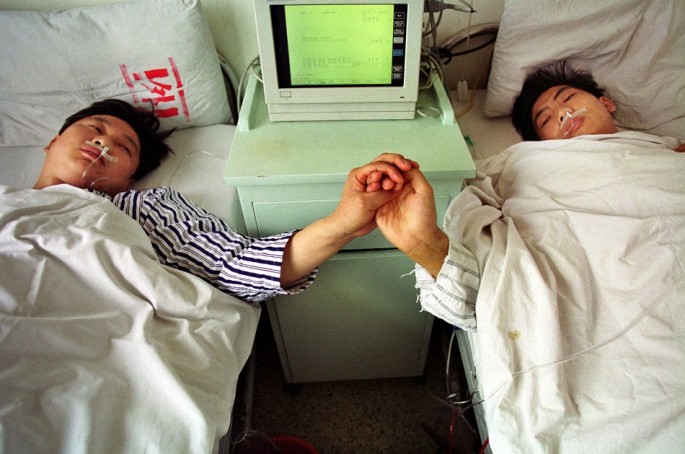Chinese brothers Sun Fusheng (L) and Sun Baosheng hold hands after China's first live nationwide television broadcast of a kidney transplant operation in Wuhan.