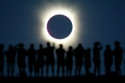 Tourists watch the sun being blocked by the moon during a solar eclipse in the Australian outback town of Lyndhurst, located around 700 kilometres (437 miles) north of Adelaide December 4, 2002. The town is one of only four in Australia where the 26 secon