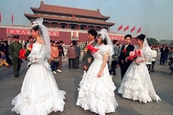 Newlywed couples stroll past Tianamen after a group marriage ceremony. 
