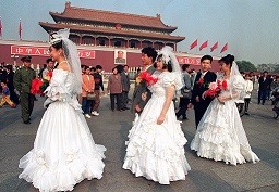 Newlywed couples stroll past Tianamen after a group marriage ceremony. 