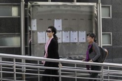 Singer Meng Ge (L) walks into court ahead of a verdict hearing for her son in Beijing, Sept. 26, 2013.