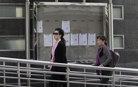 Singer Meng Ge (L) walks into court ahead of a verdict hearing for her son in Beijing, Sept. 26, 2013.