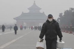 An old man wearing facial mask walks at the Temple of Heaven Park in Beijing, capital of China.