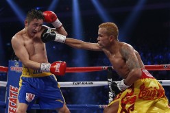 Amnat Ruenroeng (R) of Thailand punches double Olympic flyweight champion Zou Shiming of China during their IBF world flyweight title fight in Macau, March 7, 2015