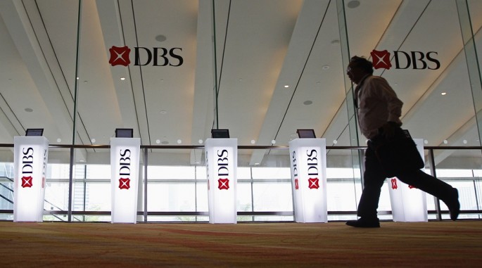 A man runs past Development Bank of Singapore (DBS) logos at a DBS function in Singapore, July 5, 2013.
