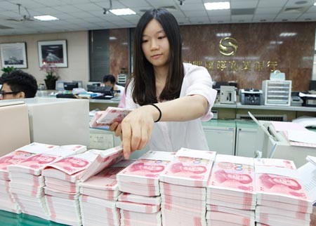 A bank employee counts yuan deposits.