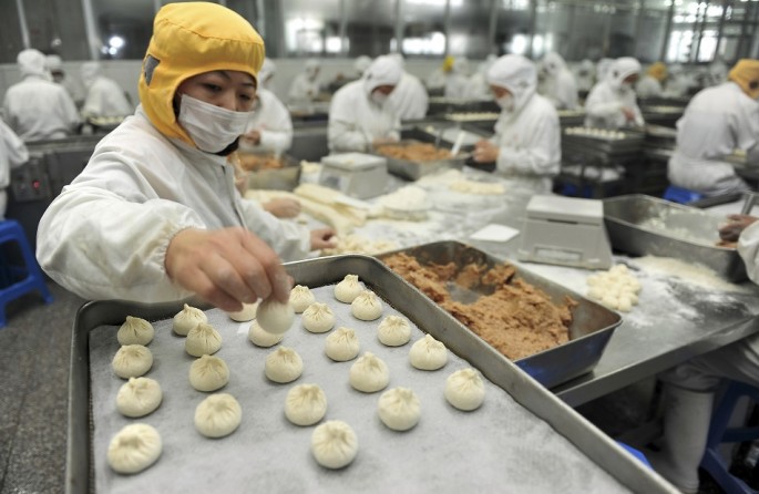 An employee makes stuffed steamed buns at a food factory in Yangzhou, Jiangsu Province.