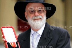 British author Terry Pratchett poses for photographers after receiving his knighthood from Britain's Queen Elizabeth at Buckingham Palace in London February 18, 2009
