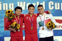 China’s Yang Jian (center) won gold at the 10-meter platform final at the first leg of the FINA World Series in Beijing on Sunday. Chinese divers won all 10 gold medals in the three-day series.