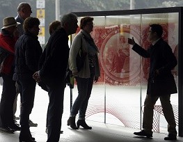 A group of visitors listens to a guide discussing about a display at Hong Kong and Shanghai Banking Corporation headquarters in Hong Kong.