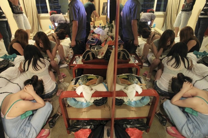 Women are seated during a police crackdown on prostitution in Wenzhou, Zhejiang Province, Sept. 12, 2012.