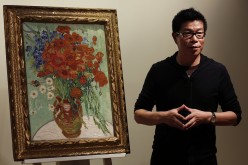 Wang Zhongjun, chairman of Huaiyi Brothers Media, stands beside Vincent van Gogh's 