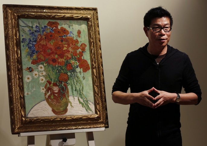 Wang Zhongjun, chairman of Huaiyi Brothers Media, stands beside Vincent van Gogh's "Vase with Daisies and Poppies" at Sotheby's in Hong Kong, Dec. 6, 2014.
