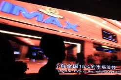 A model stands in front of a video presentation before the start of an official signing ceremony between Wanda Group and AMC Entertainment in Beijing.