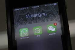 Icons of messaging applications WhatsApp of Facebook (L), Laiwang of Alibaba Group (C), and WeChat (Weixin) of Tencent Group are seen on the screen of a smartphone.