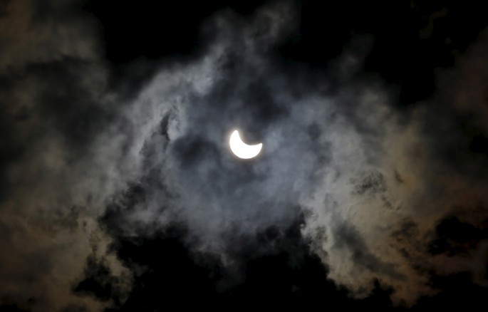 A partial eclipse of the sun is seen through clouds in Sarajevo March 20, 2015.