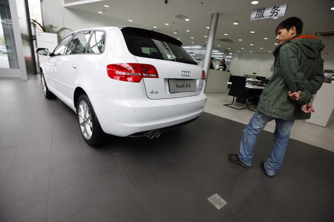 A man looks at a new Audi A3 car at a Volkswagen auto dealership in Shanghai, March 20, 2013. 
