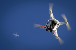 An airplane flies over a drone in the skies of New York. Chinese courier SF Express announced this week that it has been using drones to send parcels across China.