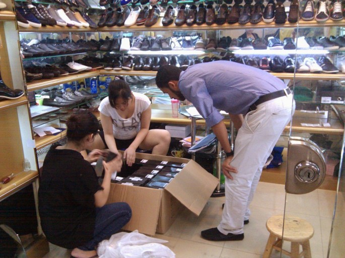 A customer looks at fake foreign brand shoes inside a store at Baiyun World Leather Market in the southern Chinese city of Guangzhou.