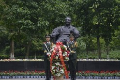Paramilitary policemen place a flower basket at the statue of late Chinese leader Deng Xiaoping on the 110th anniversary of his birth in Guang'an, Sichuan Province.