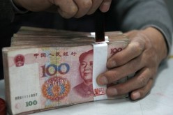 A stack of yuan banknotes sealed by an employee at a branch of Industrial and Commercial Bank of China in Huaibei, Anhui Province.