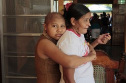A girl, who is a cancer patient, embraces her mother after a march to observe the international day of the fight against childhood cancer in Managua, Feb. 14, 2015. 